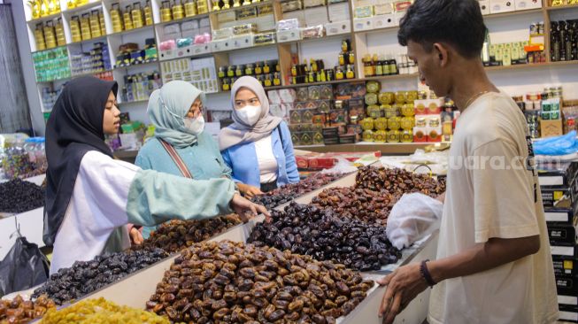 Pembeli memilih kurma yang dijual di kawasan Tanah Abang, Jakarta Pusat, Sabtu (25/3/2023). [Suara.com/Alfian Winanto]