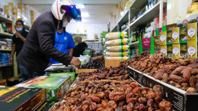 Pembeli memilih kurma yang dijual di kawasan Tanah Abang, Jakarta Pusat, Sabtu (25/3/2023). [Suara.com/Alfian Winanto]