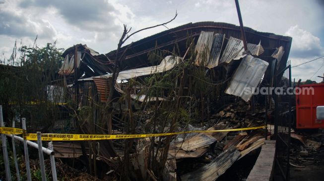 Petugas membersihkan sisa-sisa kebakaran di tempat penampungan hewan di Duren Sawit, Jakarta Timur, Senin (27/3/2023). [Suara.com/Alfian Winanto]