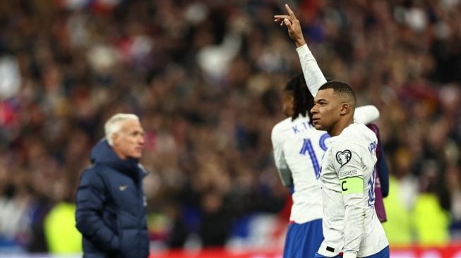 Penyerang timnas Prancis Kylian Mbappe (kanan) melakukan selebrasi dengan pelatih Didier Deschamps (kiri) pada akhir pertandingan matchday pertama Grup B kualifikasi Euro 2024 antara Prancis vs Belanda di Stade de France di Saint-Denis, utara Paris, pada 24 Maret 2023.Anne-Christine POUJOULAT / AFP.