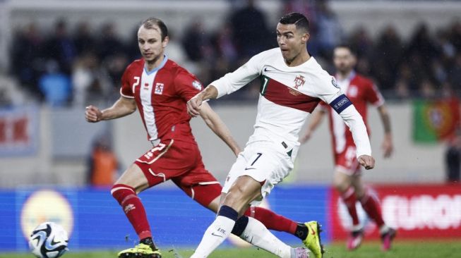 Penyerang timnas Portugal Cristiano Ronaldo (kanan) menembak dan mencetak gol keempat timnya selama matchday kedua Grup J kualifikasi Euro 2024 antara Luksemburg vs Portugal di Stade de Luxembourg, di Luksemburg, pada 26 Maret 2023.Kenzo TRIBOUILLARD / AFP