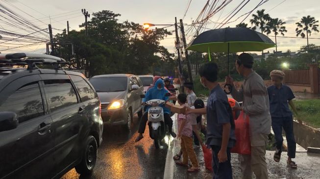 Anak-anak dan remaja warga Ahmadiyah Depok membagi-bagikan takjil di Sawangan, Depok, Jawa Barat, Minggu (26/3/2023). [Suara.com/Dea]