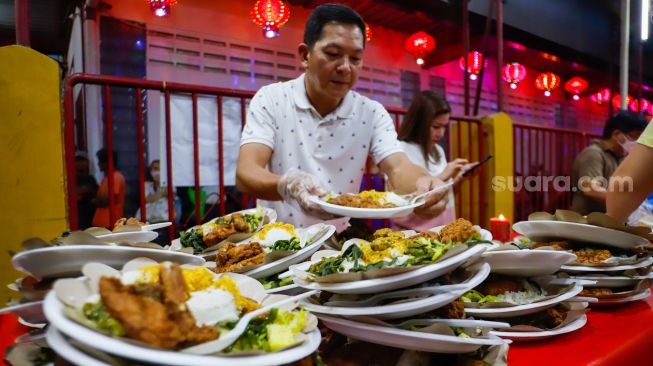 Pengurus vihara menyiapkan makanan berbuka puasa untuk warga di Vihara Dharma Bakti, Jakarta Barat, Rabu (29/3/2023). [Suara.com/Alfian Winanto]