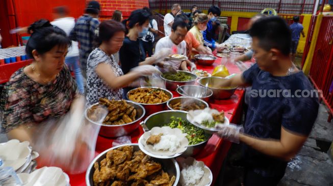 Pengurus vihara menyiapkan makanan berbuka puasa untuk warga di Vihara Dharma Bakti, Jakarta Barat, Rabu (29/3/2023). [Suara.com/Alfian Winanto]