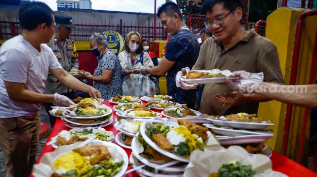 Pengurus vihara menyiapkan makanan berbuka puasa untuk warga di Vihara Dharma Bakti, Jakarta Barat, Rabu (29/3/2023). [Suara.com/Alfian Winanto]