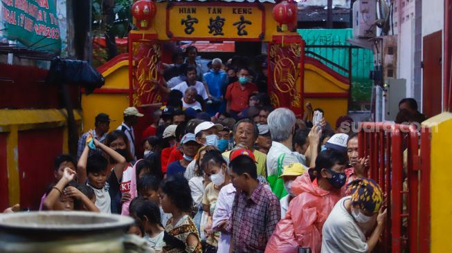 Warga mengantri untuk mendapatkan makanan buka puasa di Vihara Dharma Bakti, Jakarta Barat, Rabu (29/3/2023). [Suara.com/Alfian Winanto]