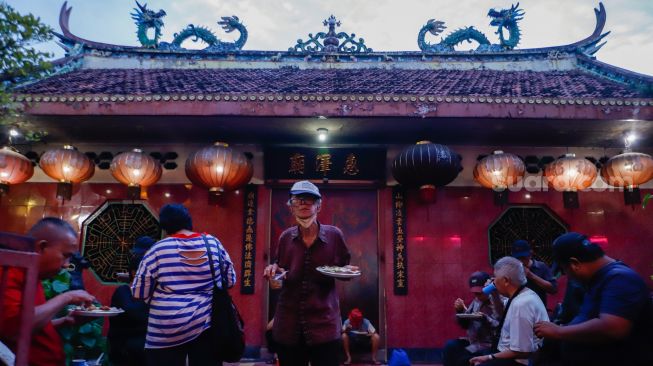 Warga menyantap makanan berbuka puasa di Vihara Dharma Bakti, Jakarta Barat, Rabu (29/3/2023). [Suara.com/Alfian Winanto]