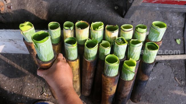 Pekerja menyelesaikan proses pembuatan lemang bambu di kawasan Senen, Jakarta, Jumat (31/3/2023). [Suara.com/Alfian Winanto]