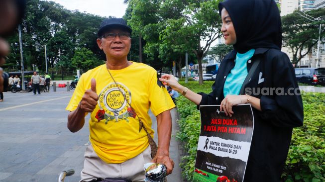 Sejumlah pecinta sepak bola mengadakan aksi di kawasan Jalan Jenderal Sudirman, Jakarta Pusat, Jumat (31/3/2023). [Suara.com/Alfian Winanto]
