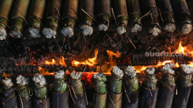 Pekerja menyelesaikan proses pembuatan lemang bambu di kawasan Senen, Jakarta, Jumat (31/3/2023). [Suara.com/Alfian Winanto]