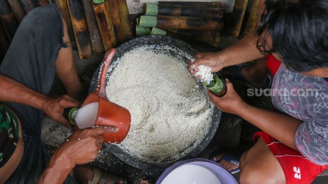 Pekerja menyelesaikan proses pembuatan lemang bambu di kawasan Senen, Jakarta, Jumat (31/3/2023). [Suara.com/Alfian Winanto]