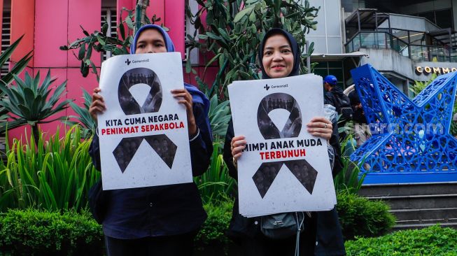 Sejumlah pecinta sepak bola mengadakan aksi di kawasan Jalan Jenderal Sudirman, Jakarta Pusat, Jumat (31/3/2023). [Suara.com/Alfian Winanto]