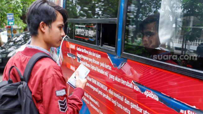 Warga menukarkan uang tunai baru di layanan kas keliling Bank Indonesia di Pasar Tebet Barat Jakarta Selatan, Selasa (4/4/2023). [Suara.com/Alfian Winanto]