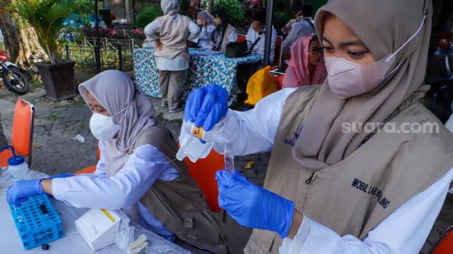 Petugas Balai Besar Pengawas Obat dan Makanan (BBPOM) DKI Jakarta menguji sampel takjil di Pasar Takjil Benhil, Jakarta Pusat, Rabu (5/4/2023). [Suara.com/Alfian Winanto]