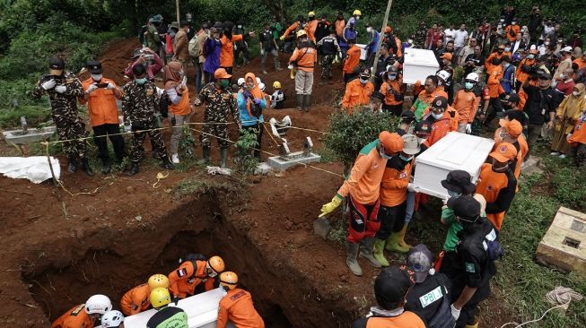 Petugas SAR gabungan membawa peti berisi jenazah korban pembunuhan berkedok penggandaan uang, untuk di makamkan di TPU Desa Balun, Wanayasa, Banjarnegara, Jateng, Selasa (4/4/2023). [ ANTARA FOTO/Idhad Zakaria].