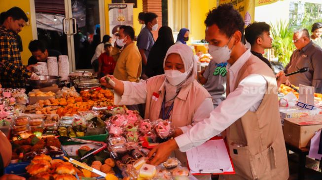 Petugas Balai Besar Pengawas Obat dan Makanan (BBPOM) DKI Jakarta menguji sampel takjil di Pasar Takjil Benhil, Jakarta Pusat, Rabu (5/4/2023). [Suara.com/Alfian Winanto]