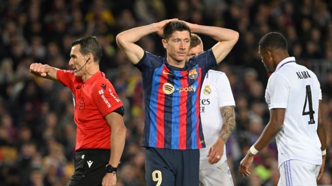 Penyerang Barcelona asal Polandia Robert Lewandowski bereaksi selama pertandingan leg kedua semifinal Copa del Rey (Piala Raja) antara FC Barcelona vs Real Madrid CF di stadion Camp Nou di Barcelona pada 5 April 2023.GEN LLUIS / AFP.