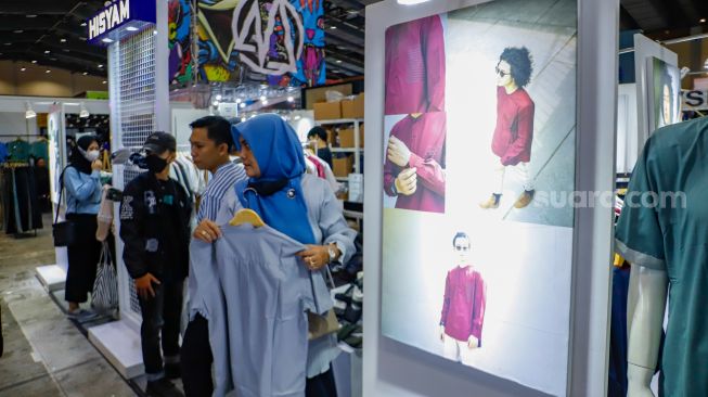 Pengunjung memilih pakaian yang dijual dalam JakCloth Ramadan 2023 di Hall B Jakarta Convention Center (JCC), Senayan, Jakarta, Sabtu (8/4/2023). [Suara.com/Alfian Winanto]