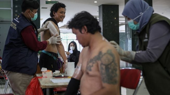 Petugas memberikan pembiusan kepada warga sebelum hapus tato di Masjid Assahara, Jakarta Barat, Senin (27/3/2023). [ANTARA FOTO/Fauzan].