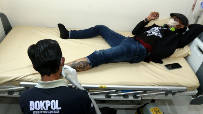 Petugas kesehatan menghapus tato pada kaki seorang warga saat program hapus tato di Klinik Pratama Polresta Banyuwangi, Jawa Timur, Senin (10/4/2023).[ANTARA FOTO/Budi Candra Setya].