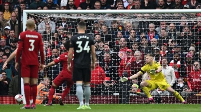 Penjaga gawang Arsenal Aaron Ramsdale (kanan) melihat bola melebar dari gawangnya saat penyerang Liverpool Mohamed Salah (tak terlihat) gagal mengeksekusi penalti pada laga sepak bola Liga Utama Inggris antara Liverpool dan Arsenal di Anfield di Liverpool, barat laut Inggris pada 9 April , 2023. Paul ELLIS / AFP