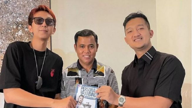 Crazy Rich Surabaya Tom Liwafa menyerahkan buku kepada Bayu Walker (kiri).[Instagram/tomliwafa]