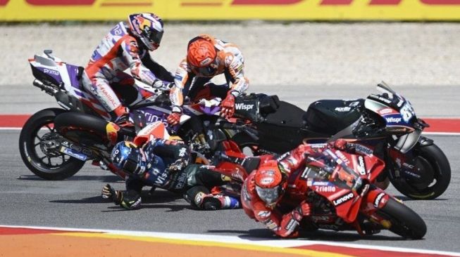 Marc Marquez dari Honda Repsol (tengah, atas) terlibat crash dengan pebalap CryptoDATA RNF Miguel Oliveira (tengah, bawah) saat pebalap Lenovo Ducati Francesco Bagnaia (depan) menyalip keduanya di sela MotoGP Portugal di Sirkuit Internasional Algarve Portimao, Portugal (26/3/2023). (ANTARA/AFP/Patricia de Melo Moreira/aa.)