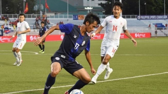 Pemain Kamboja Sieng Chanthea (Kiri) mengontrol bola melawan Thu Rein Soe dari Myanmar (kanan) selama pertandingan sepak bola untuk perebutan tempat ketiga antara Kamboja dan Myanmar di SEA Games Manila. WAKIL KOHSAR / AFP