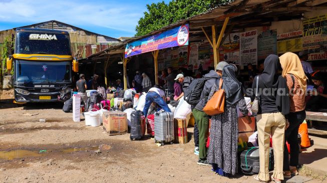 Penumpang bersiap menanti kedatangan bus di Terminal Pondok Pinang, Jakarta Selatan, Kamis (13/4/2023). [Suara.com/Alfian Winanto]