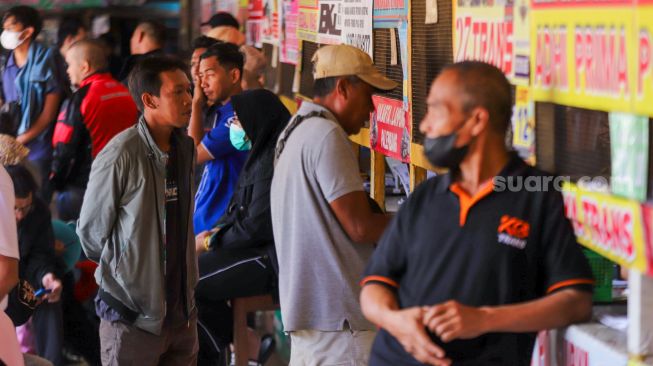 Penumpang bersiap menanti kedatangan bus di Terminal Pondok Pinang, Jakarta Selatan, Kamis (13/4/2023). [Suara.com/Alfian Winanto]