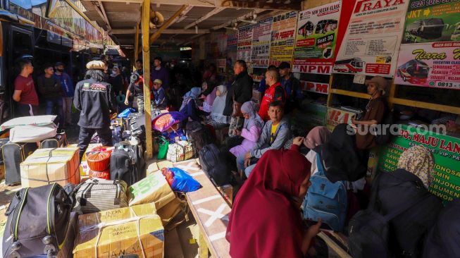 Penumpang bersiap menanti kedatangan bus di Terminal Pondok Pinang, Jakarta Selatan, Kamis (13/4/2023). [Suara.com/Alfian Winanto]