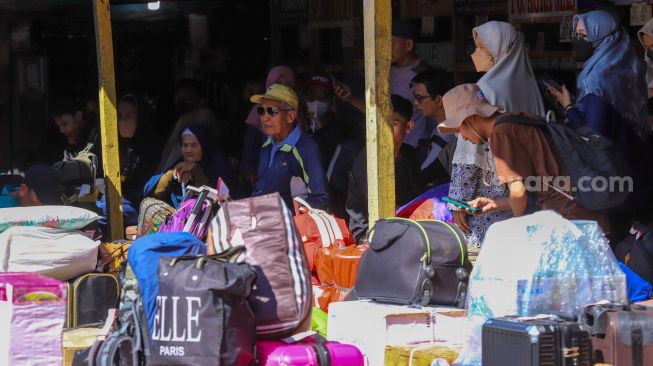 Penumpang bersiap menanti kedatangan bus di Terminal Pondok Pinang, Jakarta Selatan, Kamis (13/4/2023). [Suara.com/Alfian Winanto]