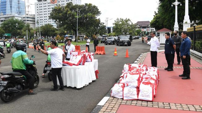 Presiden Joko Widodo atau Jokowi bersama Menteri BUMN Erick Thohir menyaksikan pembagian sembako untuk ojek online di depan Istana Merdeka, Jakarta, Kamis (13/4/2023). [Foto: Kris - Biro Pers Sekretariat Presiden]