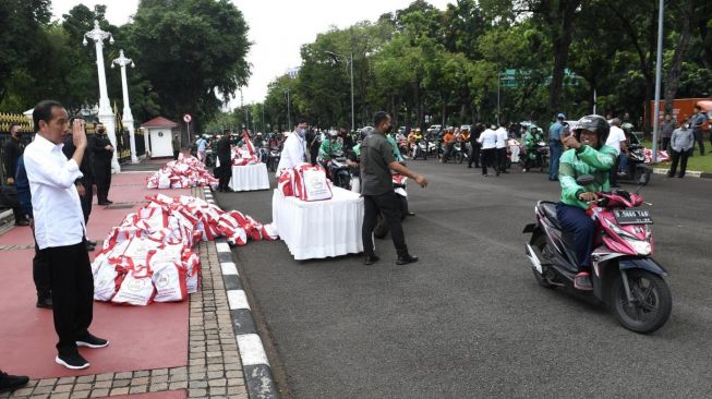 Presiden Joko Widodo atau Jokowi bersama Menteri BUMN Erick Thohir menyaksikan pembagian sembako untuk ojek online di depan Istana Merdeka, Jakarta, Kamis (13/4/2023). [Foto: Kris - Biro Pers Sekretariat Presiden]