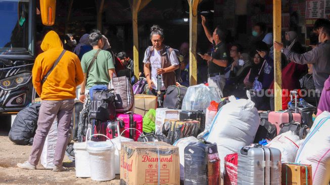 Penumpang bersiap menanti kedatangan bus di Terminal Pondok Pinang, Jakarta Selatan, Kamis (13/4/2023). [Suara.com/Alfian Winanto]