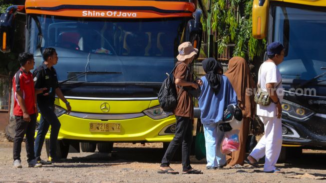 Penumpang bersiap menaiki kedatangan bus di Terminal Pondok Pinang, Jakarta Selatan, Kamis (13/4/2023). [Suara.com/Alfian Winanto]