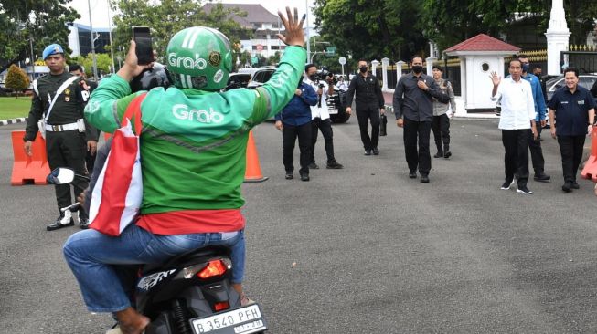 Presiden Joko Widodo atau Jokowi bersama Menteri BUMN Erick Thohir menyaksikan pembagian sembako untuk ojek online di depan Istana Merdeka, Jakarta, Kamis (13/4/2023). [Foto: Kris - Biro Pers Sekretariat Presiden]