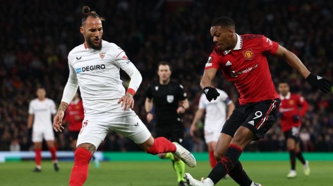 Penyerang Manchester United (MU) Anthony Martial (kanan) melepaskan umpan silang di pertandingan leg pertama perempat final Liga Europa lawan Sevilla, di Old Trafford pada 14 April 2023. ANTARA/AFP/DARREN STAPLES