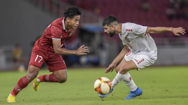 Pesepak bola Timnas Indonesia U-22 Irfan Jauhari (kiri) berusaha melewati hadangan pesepak bola Timnas Lebanon U-22 Abdul Razzak (kanan) dalam pertandingan Internasional Friendly Match di Stadion Utama Gelora Bung Karno, Jakarta, Jumat (14/4/2023). Timnas Indonesia U-22 kalah atas Timnas Lebanon U-22 dengan skor 1-2. ANTARA FOTO/Galih Pradipta/rwa. 