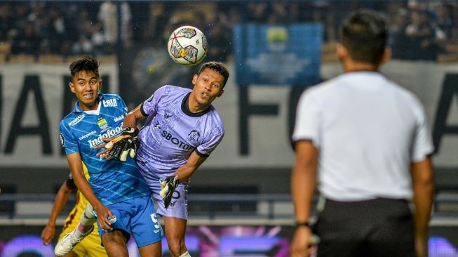 Pesepak bola Persib Bandung Kakang Rudianto berduel bola udara dengan penjaga gawang Persikabo Syahrul Trisna saat pertandingan lanjutan BRI Liga 1 di Stadion Gelora Bandung Lautan Api, Bandung, Jawa Barat, Sabtu (15/4/2023). ANTARA FOTO/Raisan Al Farisi/aww. 