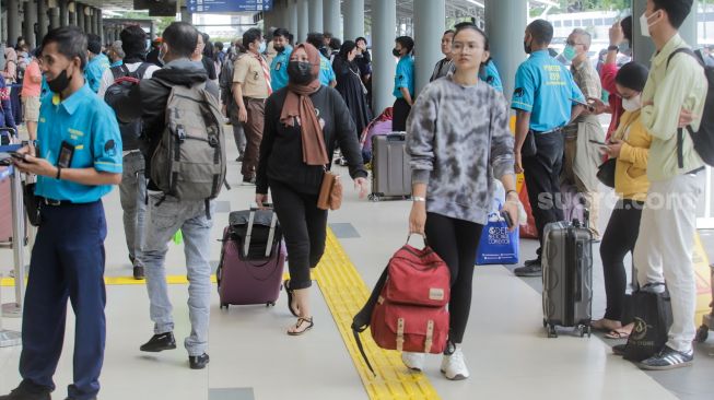 Penumpang bersiap menunggu keberangkatan Kereta Api di Stasiun Pasar Senen, Jakarta Pusat, Senin (17/4/2023). [Suara.com/Alfian Winanto]