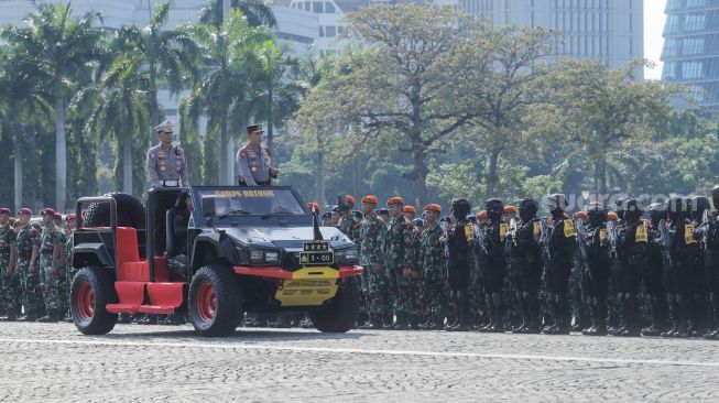 Kapolri Jendral Listyo Sigit Prabowo (kanan) mengecek pasukan saat Apel Gelar Pasukan Operasi Ketupat 2023 di Lapangan Monas, Jakarta Pusat, Senin (17/4/2023). [Suara.com/Alfian Winanto]