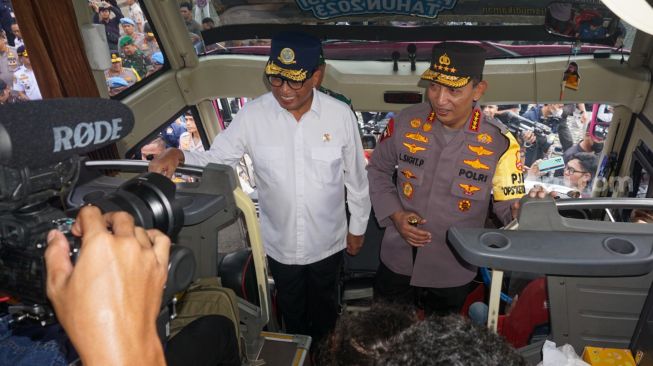 Menteri Perhubungan Budi Karya Sumadi (kiri) dan Kapolri Jendral Listyo Sigit Prabowo (kanan) saat meninjau peserta Mudik Gratis Polri 2023 di kawasan Silang Monas, Jakarta Pusat, Selasa (18/4/2023). [Suara.com/Alfian Winanto]