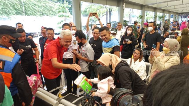 Ganjar Pranowo membagi-bagikan mainan kepada anak keluarga pemudik di Stasiun Pasar Senen. (Suara.com/Dea)