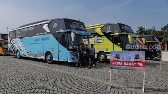 Peserta Mudik Gratis Polri 2023 menaiki bus di kawasan Silang Monas, Jakarta Pusat, Selasa (18/4/2023). [Suara.com/Alfian Winanto]