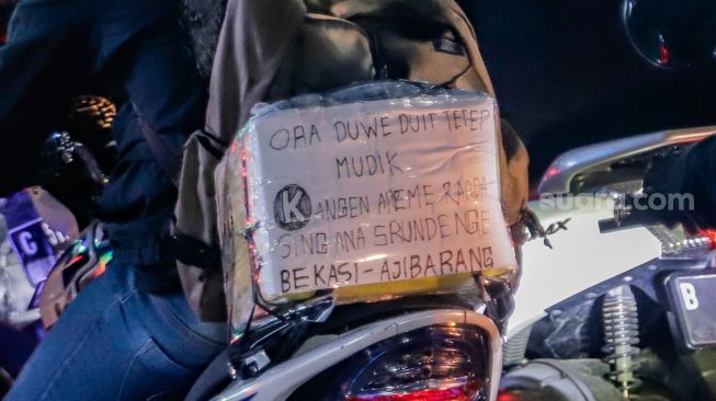 Pemudik yang menggunakan sepeda motor melintas di Jalan Raya Kalimalang, Jakarta Timur, Rabu (19/4/2023) malam. [Suara.com/Alfian Winanto]