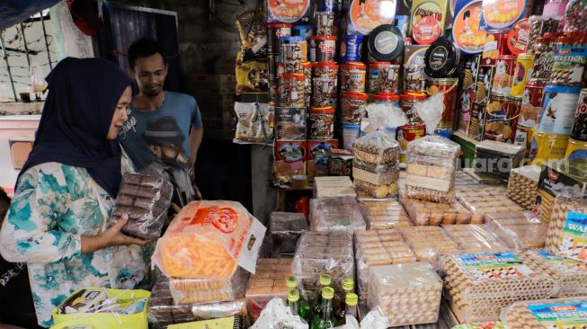 Pembeli memilih kue kaleng di salah satu toko kue kering di kawasan Ciracas, Jakarta Timur, Kamis (20/4/2023). [Suara.com/Alfian Winanto]