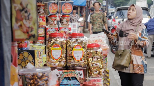 Pembeli memilih kue kaleng di salah satu toko kue kering di kawasan Ciracas, Jakarta Timur, Kamis (20/4/2023). [Suara.com/Alfian Winanto]