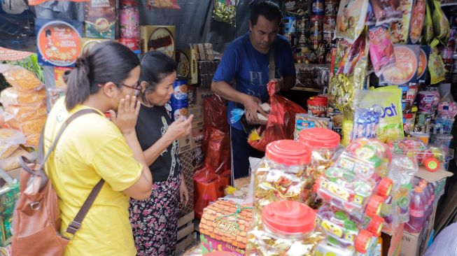 Pembeli memilih kue kaleng di salah satu toko kue kering di kawasan Ciracas, Jakarta Timur, Kamis (20/4/2023). [Suara.com/Alfian Winanto]