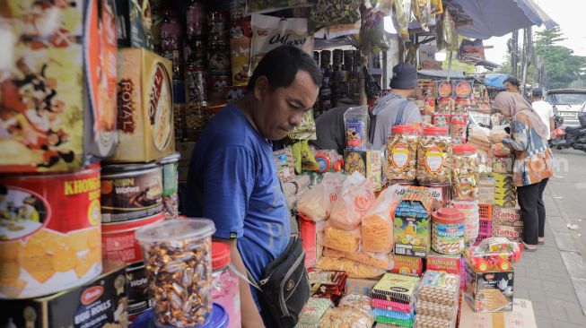 Pembeli memilih kue kaleng di salah satu toko kue kering di kawasan Ciracas, Jakarta Timur, Kamis (20/4/2023). [Suara.com/Alfian Winanto]